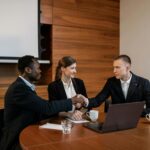 Professionals shaking hands at a business meeting, showcasing teamwork and collaboration.
